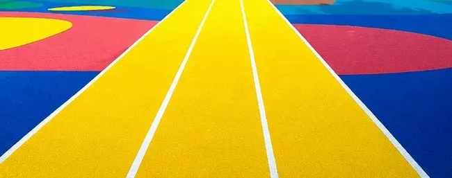 Yellow EPDM jogging lanes on a coloured play surface
